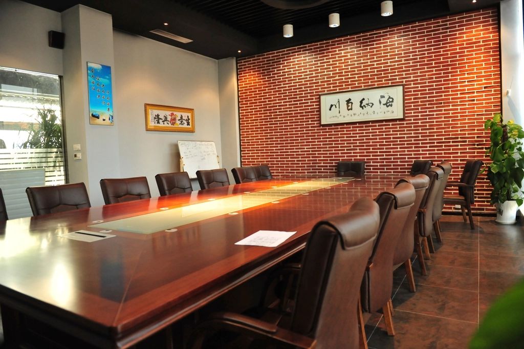 A meeting room with a long table and chairs