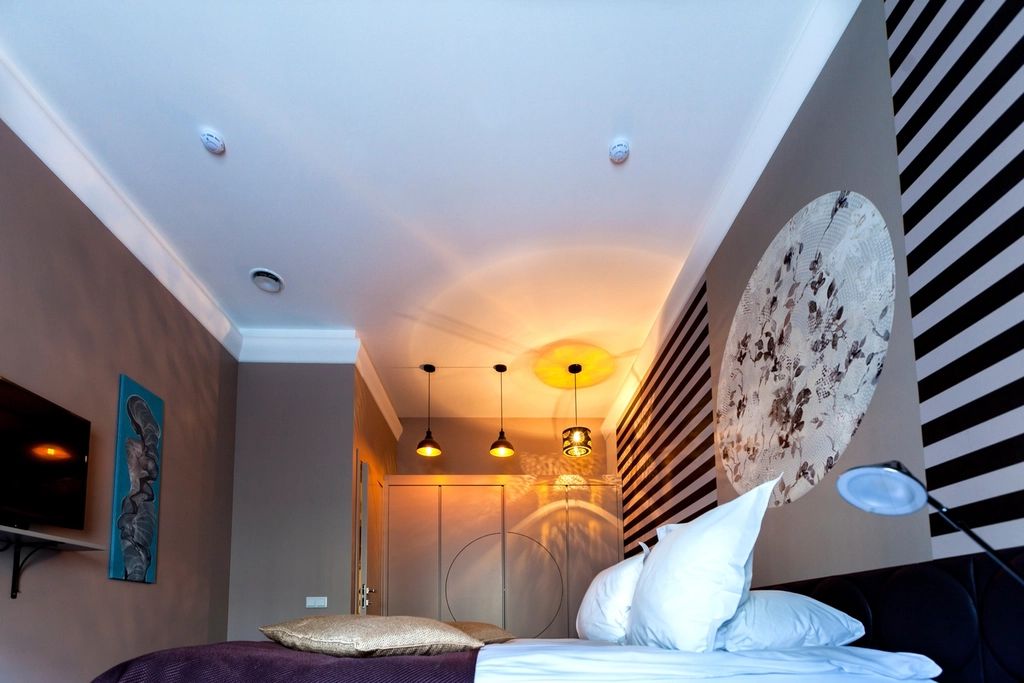 A guest room with a large bed and soft lighting