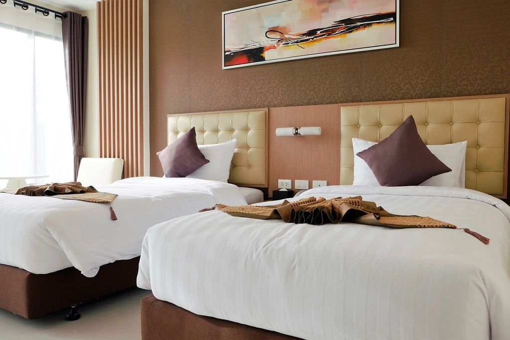 A guest room with a large bed and soft lighting